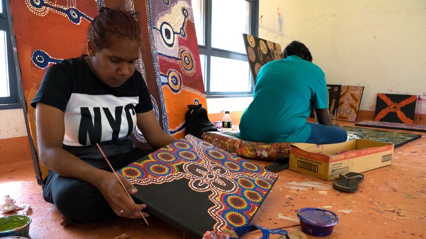 Indigenous artists paint in a workshop in the APY Lands.