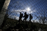 Asylum seekers walk along Hungary's border fence.