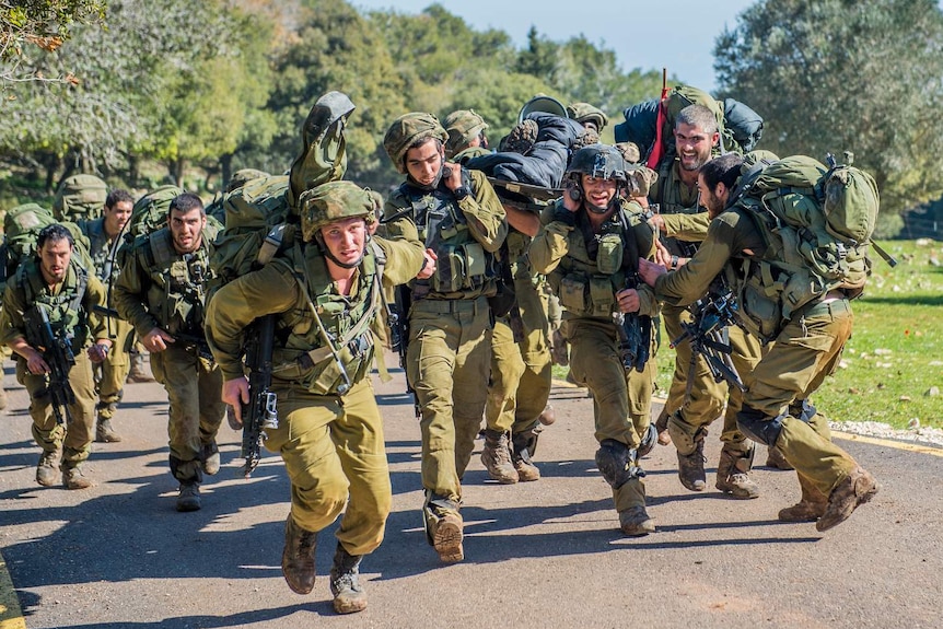 A group of Israeli soldiers carry a stretcher.