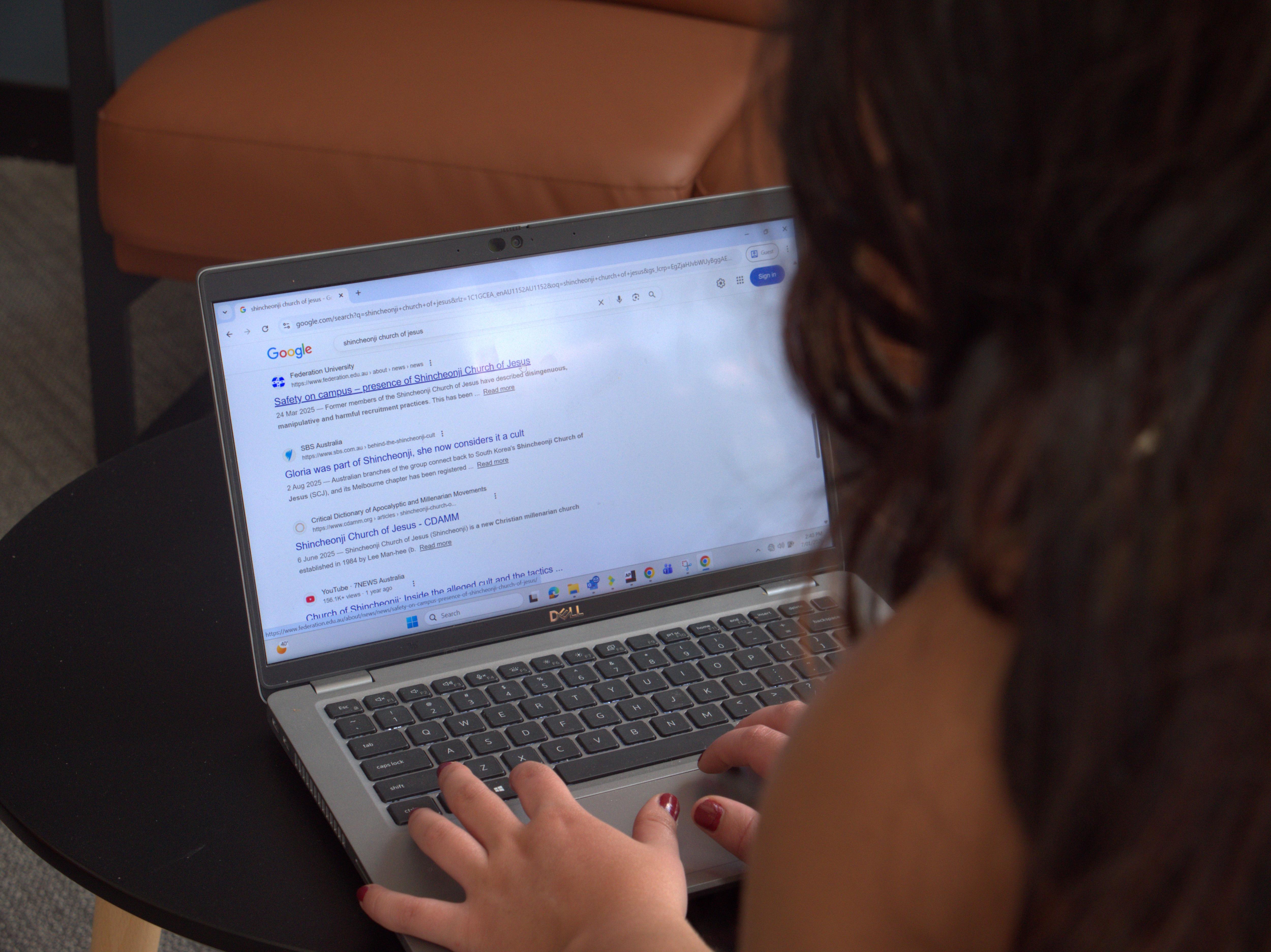 Uma mulher em um laptop procurando informações sobre Shincheonji