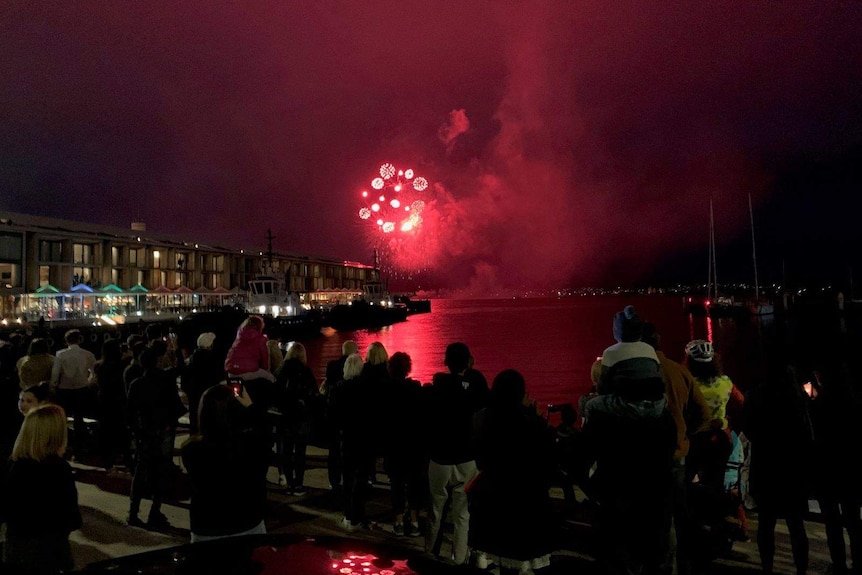 Families gather for an early fireworks display in Hobart.