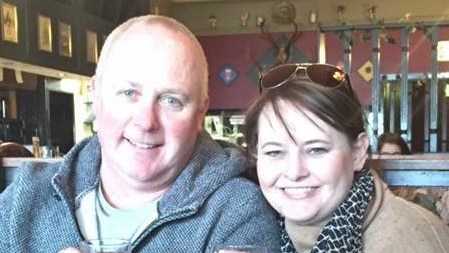 A man and a woman holding a beer and a wine glass