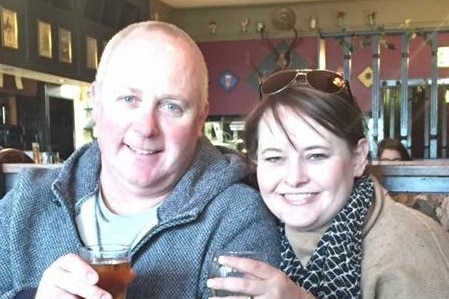 A man and a woman holding a beer and a wine glass