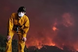 19-year-old India MacDonell with fire burning in ranges behind her.