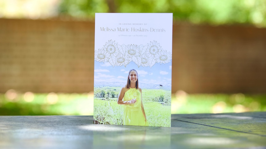 A small booket with a picture of a smiling woman wearing a yellow dress on the cover. 