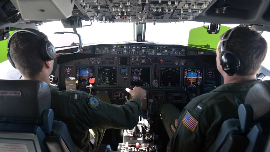 US naval aviators Lt Kyle Atakturk (L) and Lt Nicholas Horton (R) piloting a P-8A Poseidon plane over the Indian Ocean