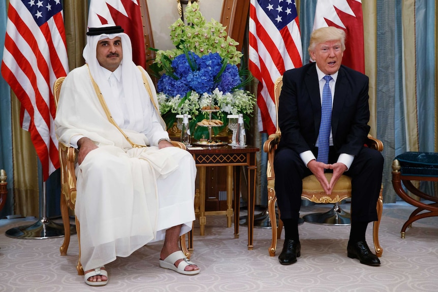 Donald Trump sits next to Qatar's emir.