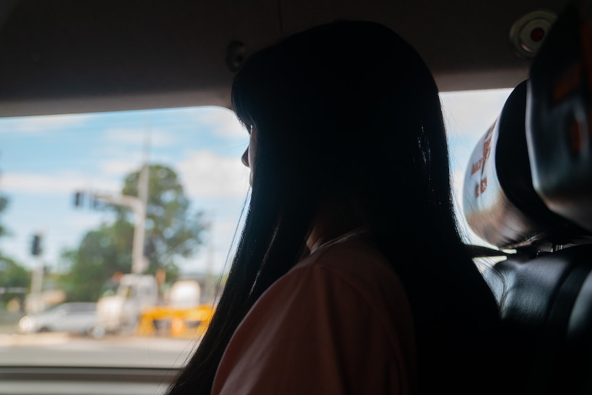 side profile of a woman in a car, her face not visible