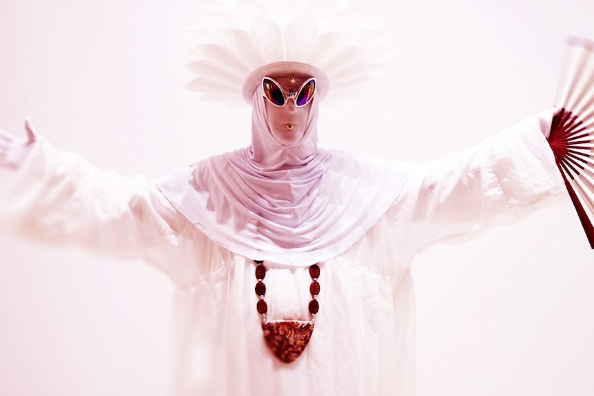 A performer dressed in religious garb with an alien styling.