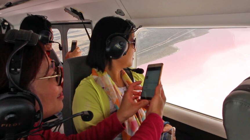 Chinese tourists on a flight over the pink lakes at Hutt Lagoon.