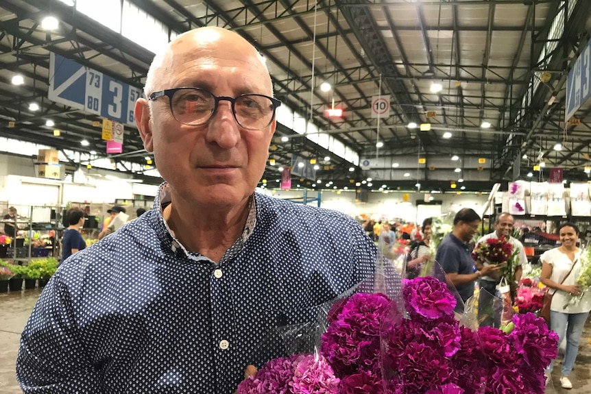 Bernard Pollack, a florist holding flowers in the Sydney flower market.