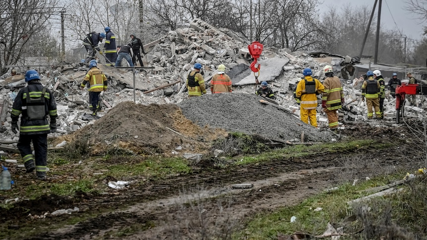 Rescuers dig through rubble at the site of a destroyed residential building in Ukraine.
