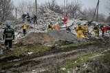 Rescuers dig through rubble at the site of a destroyed residential building in Ukraine.