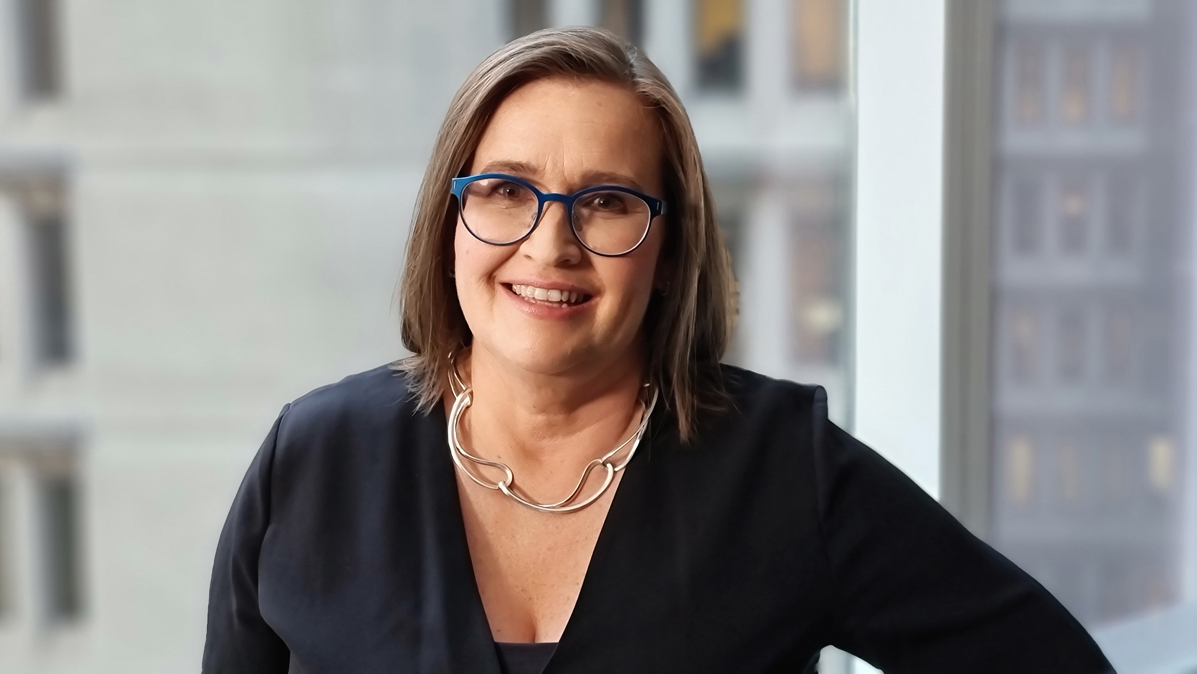 A woman wearing glasses and a black top.