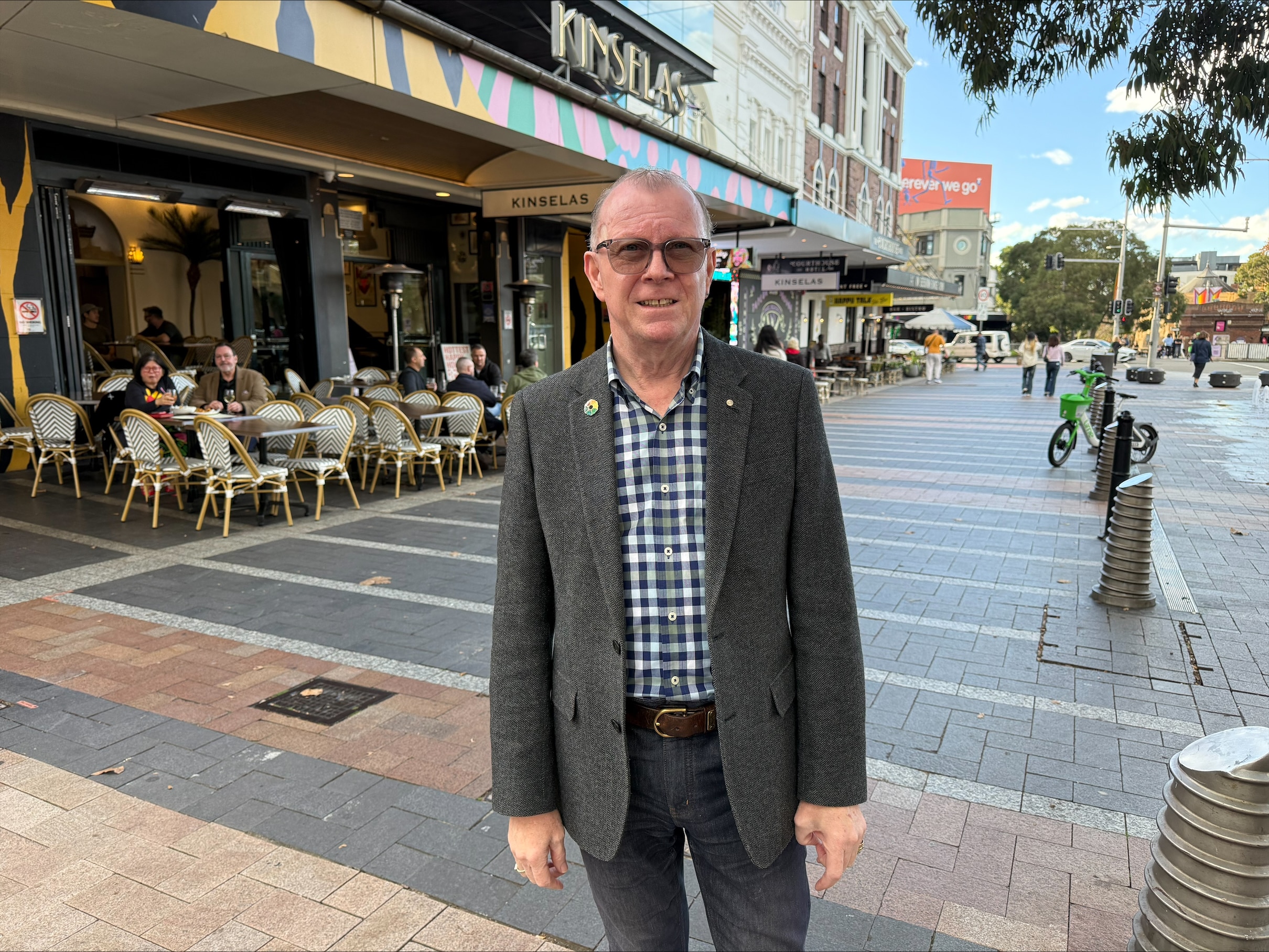 78er Rebbell Barnes wears glasses as he stands outdoors talking to a reporter
