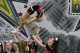 A girl in mid-air during a cheerleading flip