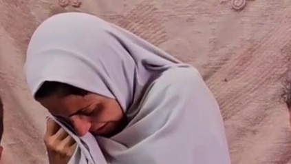 A woman in a white hijab crying