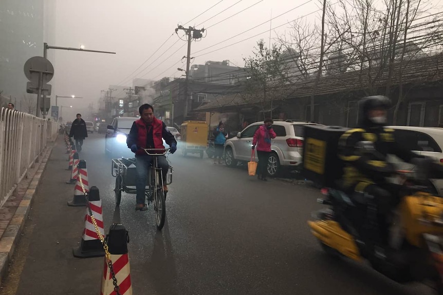 People travel on roads in Beijing, China amid smog and air pollution