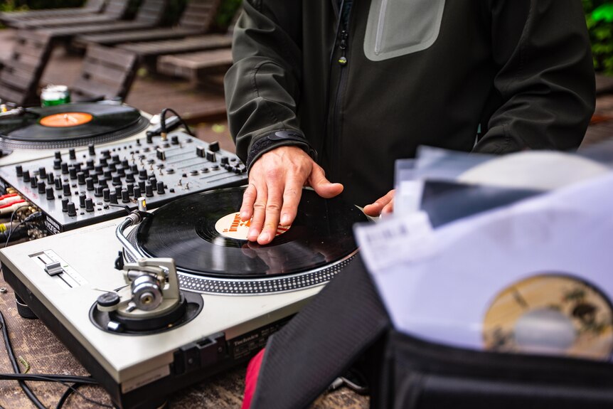 Un DJ mixant des chansons à l'aide de vinyles et de platines.