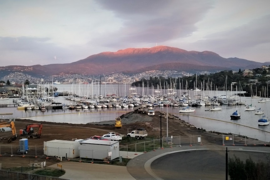 Construction site near marina near Hobart city and mountain in background.