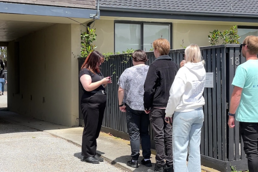 people wait in line to inspect a rental property