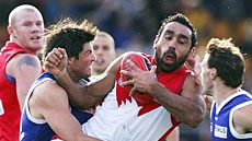 Adam Goodes is crunched by the Kangaroos defence.