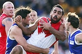 Adam Goodes is crunched by the Kangaroos defence.