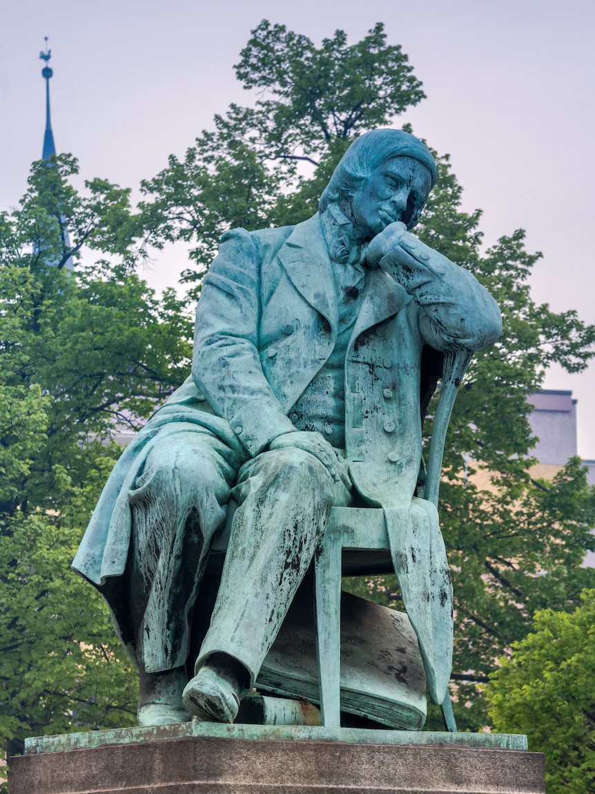 A statue of a man sitting on a chair.