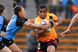 Elsie Albert has the ball and is running hard as a Fiji player tries to tackle her.