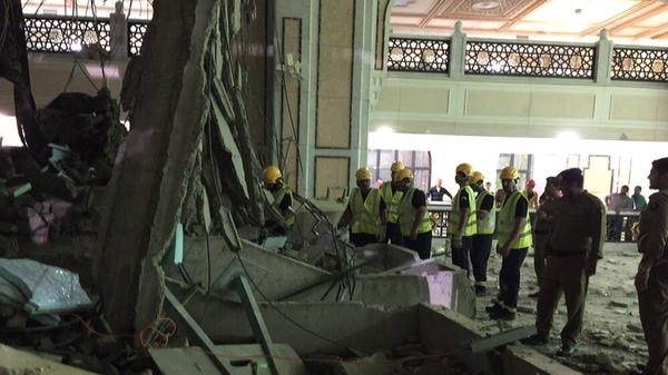 Workmen inspect wreckage from the collapsed crane