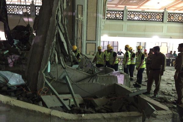 Workmen inspect wreckage from the collapsed crane