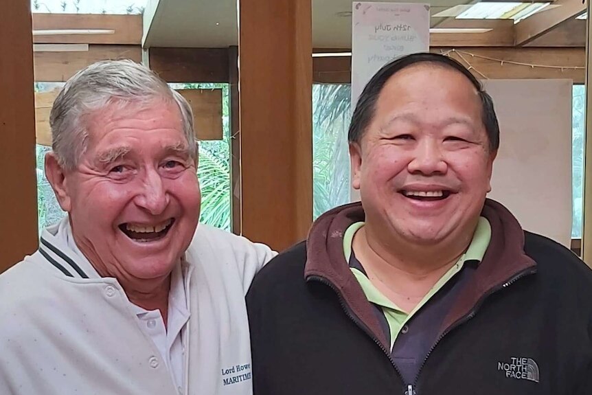 Man with dark hair smiles at camera