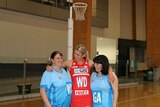 Allie wears her red Swifts dress and smiles as she stands in the middle with her arms around Mel and Nalyn in their blue NSW kit