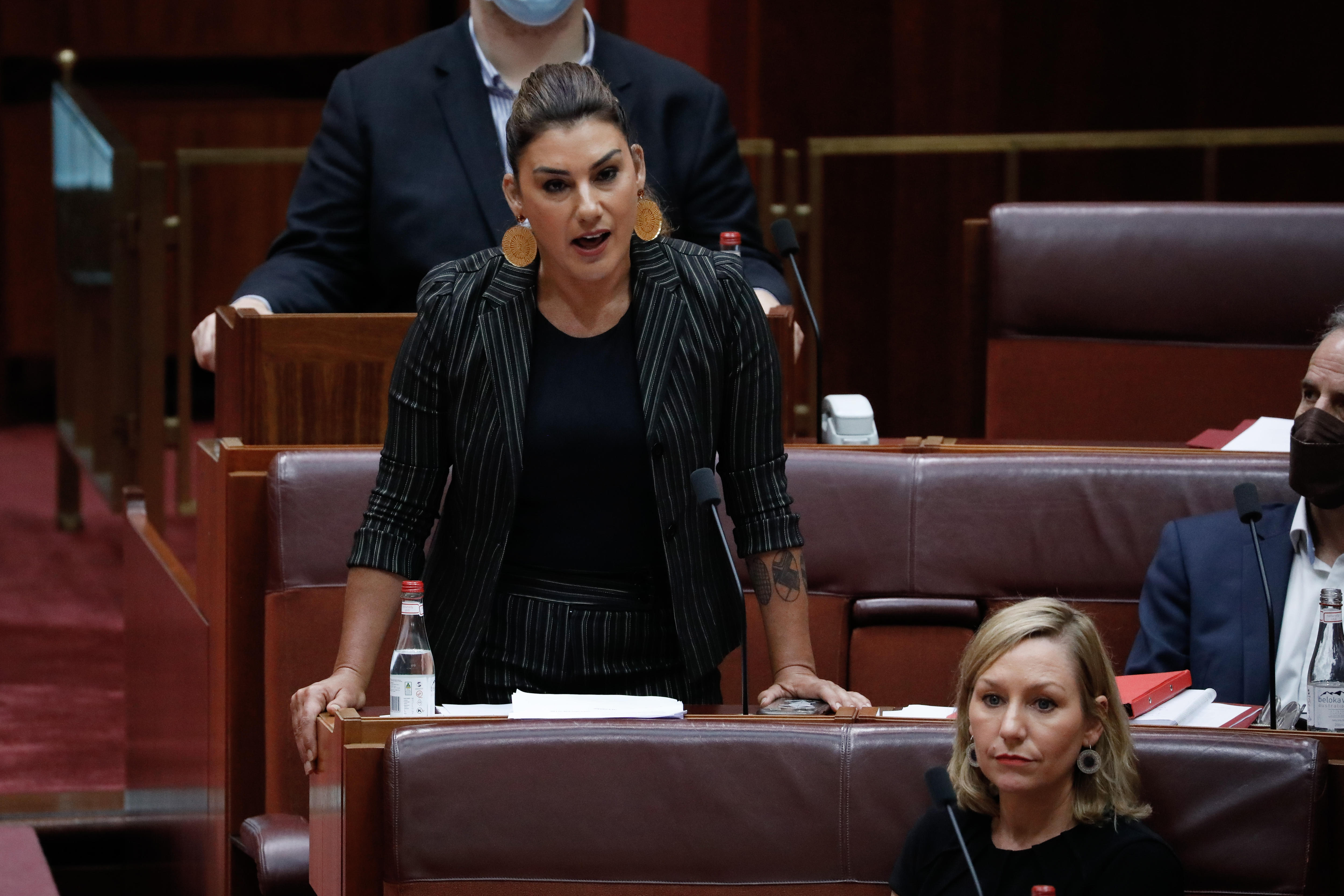 Η Λίντια Θορπ ακουμπάει με τα δύο χέρια στο γραφείο της στο μέσο της ομιλίας της.