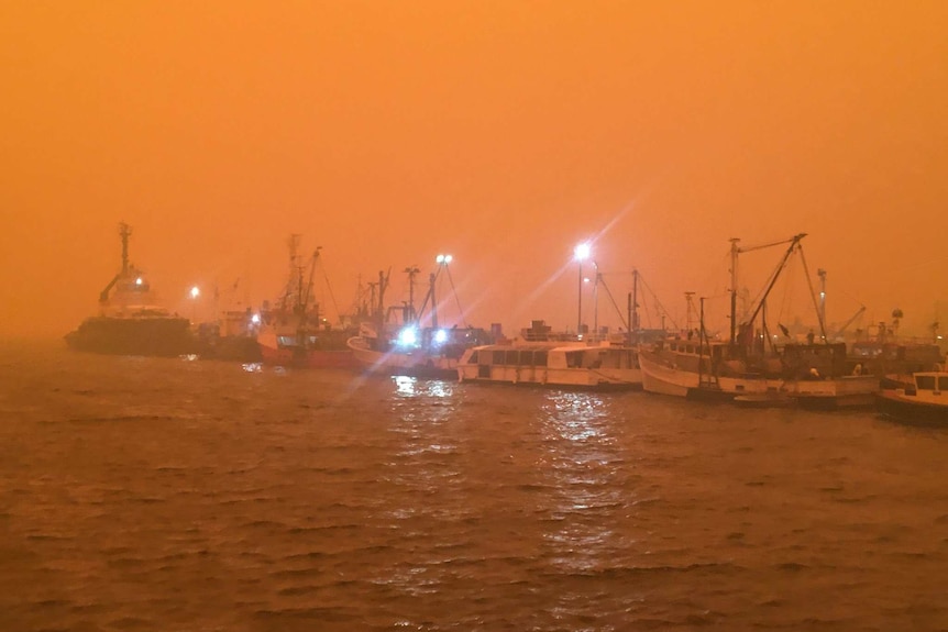An orange sky over boats in the harbour of Eden on the New South Wales South Coast.