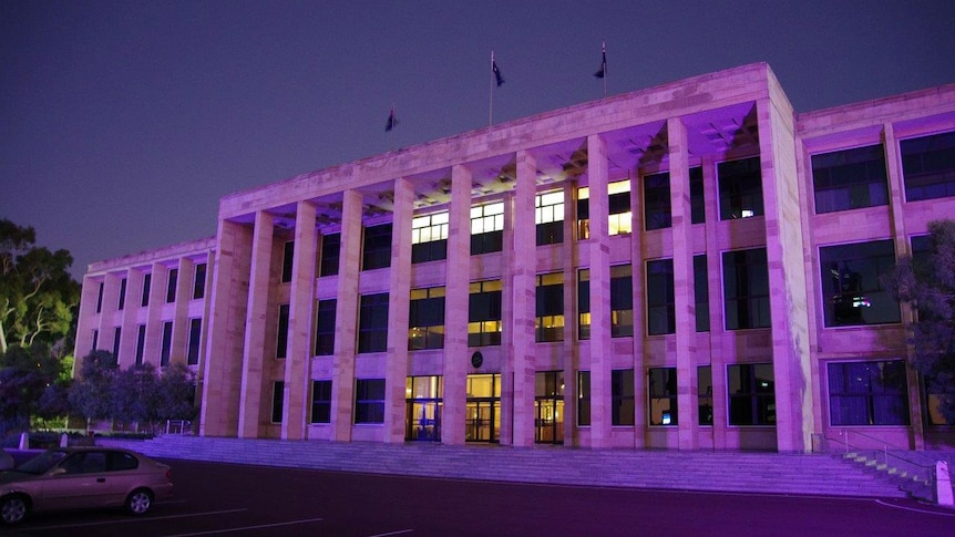 A wide shot of the front steps of Parliament House in Perth at dawn, with the building appearing purple in the morning light.