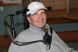 City of Kalgoorlie-Boulder councillor Mick McKay wearing a white cap and grey jumper sitting in a wheelchair.