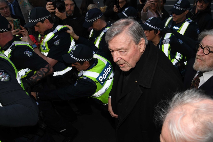 George Pell, surrounded by police, as he arrives at court in Melbourne