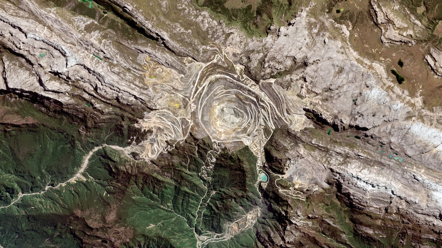 A satellite image of the Grasberg Mine in West Papua - a deep stepped pit