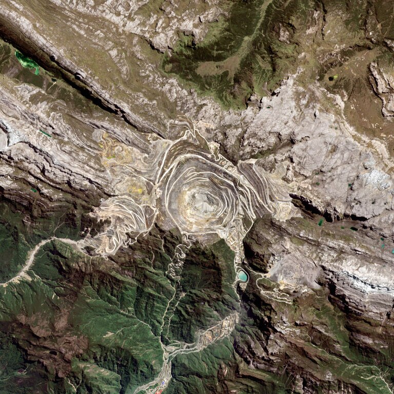 A satellite image of the Grasberg Mine in West Papua - a deep stepped pit
