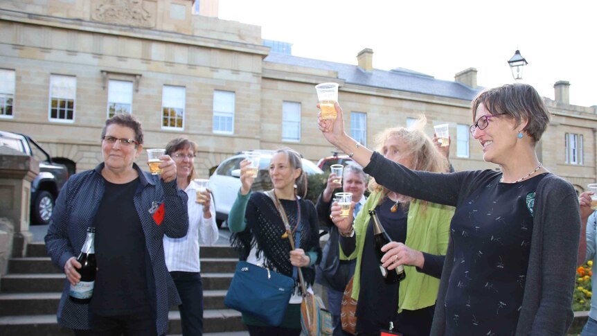 People raising glasses outside Tasmania's Parliament.