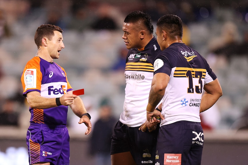 Len Ikitau (centre) reacts with frustration as he is shown a red card by referee Paul Williams 