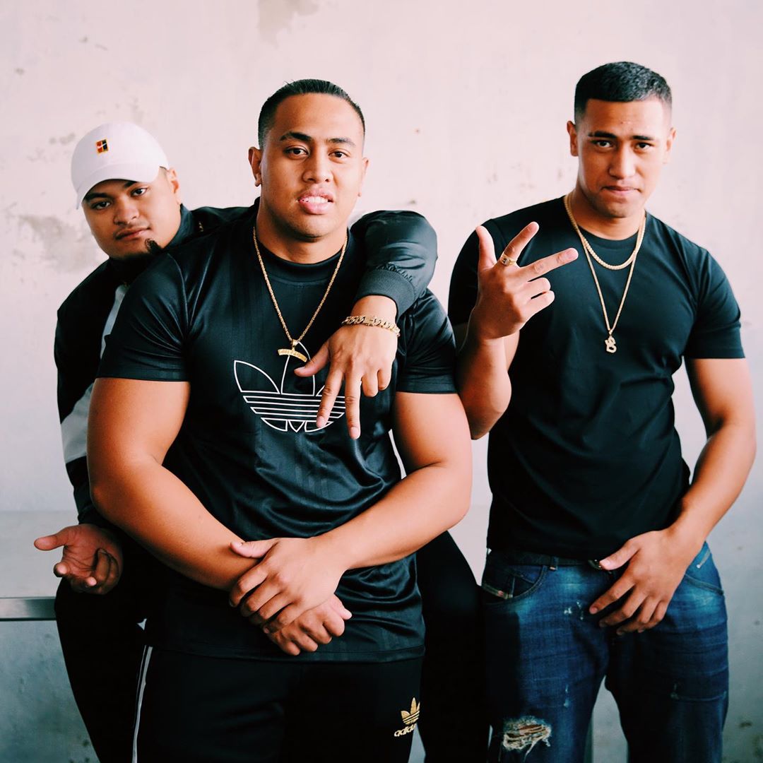 three men in black shirts looking at the camera