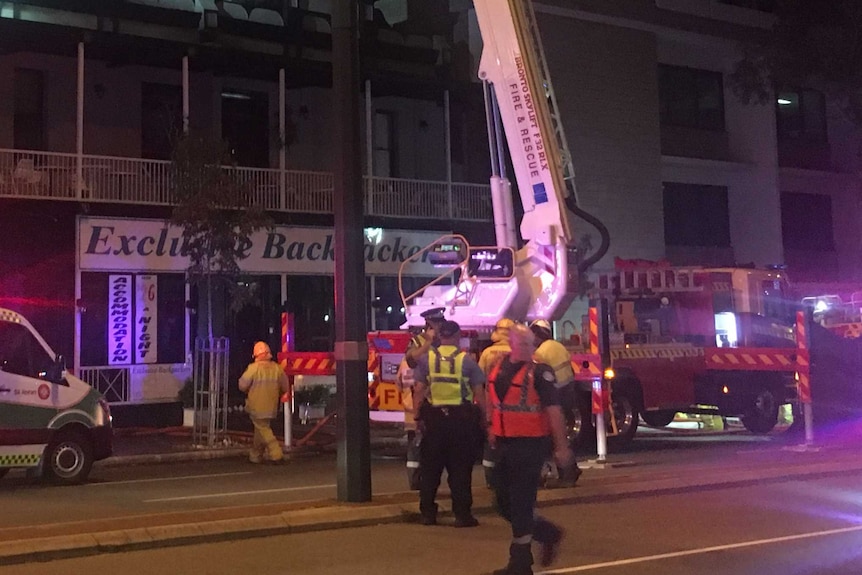 Fire crews outside a backpacker hostel at night.