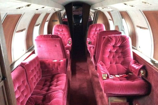 The interior of the 1962 Lockheed Jetstar, with red velvet seats and red carpet.