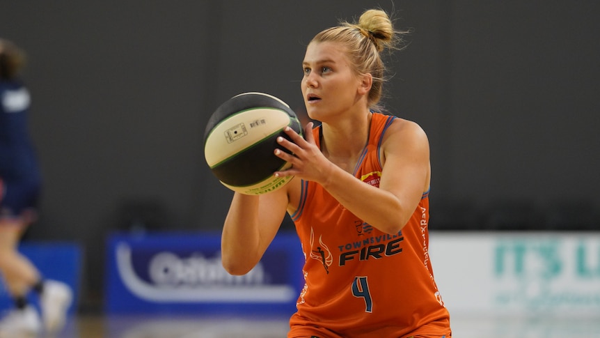 Female basketball player shooting for goal during a match.