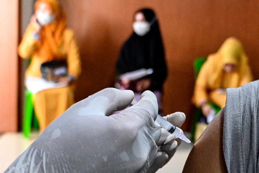 一名卫生工作者正在注射一剂Sinovac冠状病毒疫苗。