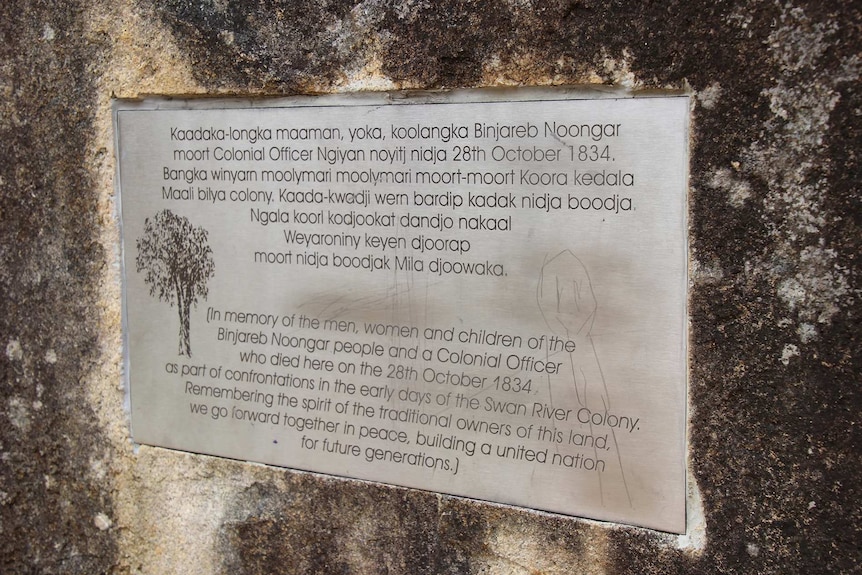 A plaque on a rock with words in Noongar and English.