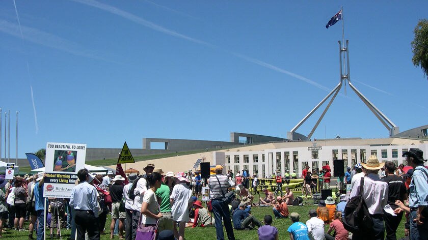 Protesters gather outside Parliament House in Canberra for the Walk Against Warming.