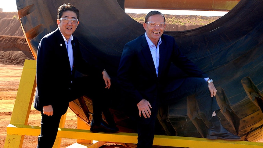 Tony Abbott and Shinzo Abe show off the RM Williams boots in front of a tyre